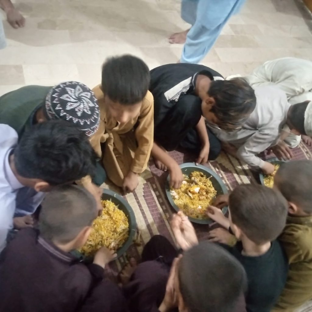 Children eating rice to break their Ramadan fast.