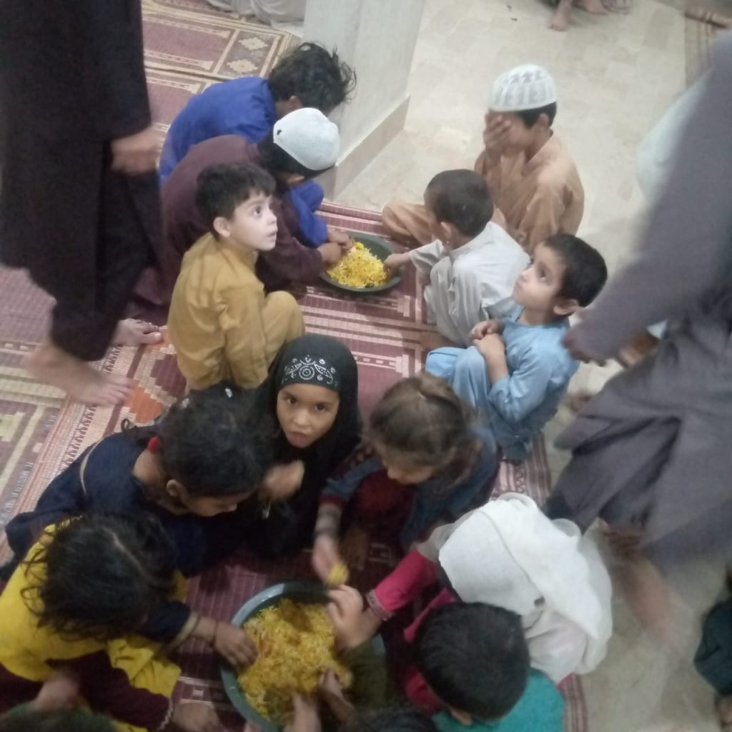 Smiling children eating rice to break their Ramadan fast.